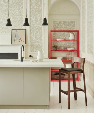 accent colors for a white kitchen, white kitchen with damask style wallpaper, kitchen island, black trio of small pendants, red shelving unit, white floor