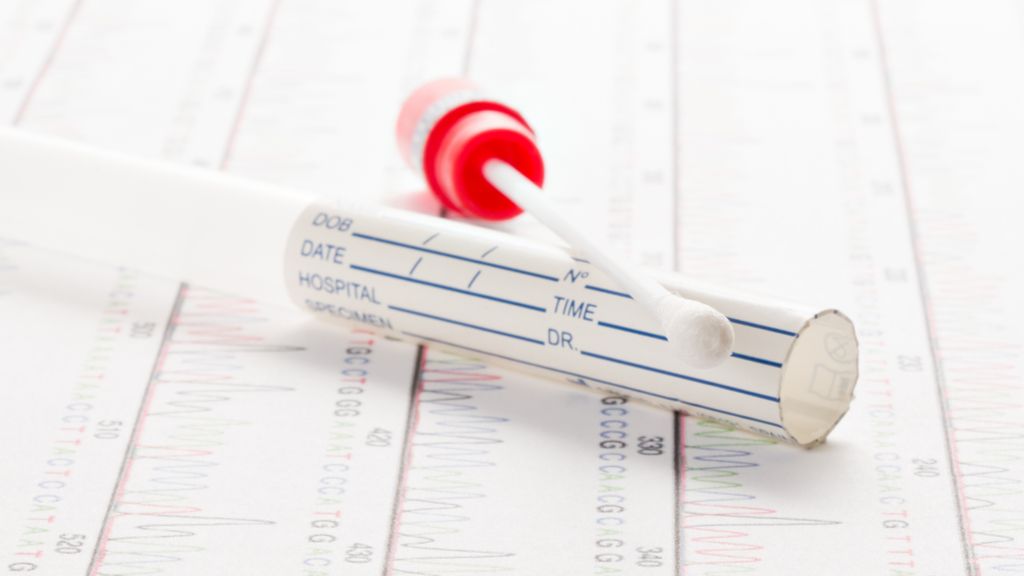 genetic swab test sitting on top of chart of genetic data