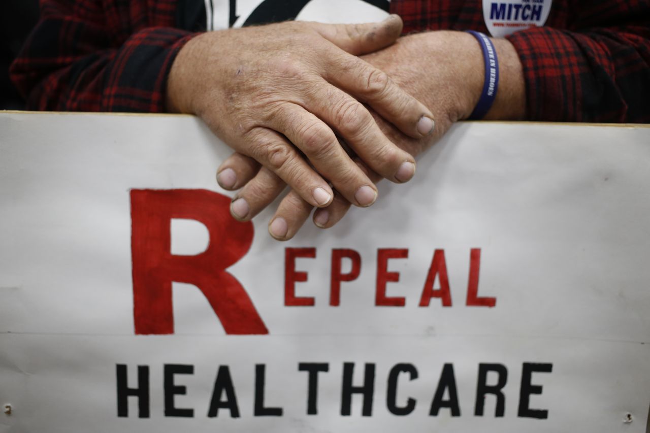 A man holds a protest sign at a rally in Kentucky