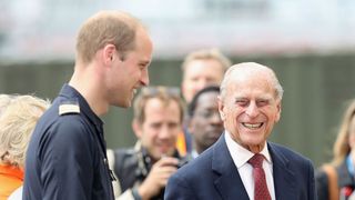 Prince William, Duke of Cambridge jokes with Prince Philip, Duke of Edinburgh as he says goodbye after visiting the new East Anglian Air Ambulance Base at Cambridge Airport on July 13, 2016 in Cambridge, England