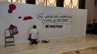 Graffiti artist working on NetApp mural at insight 2024