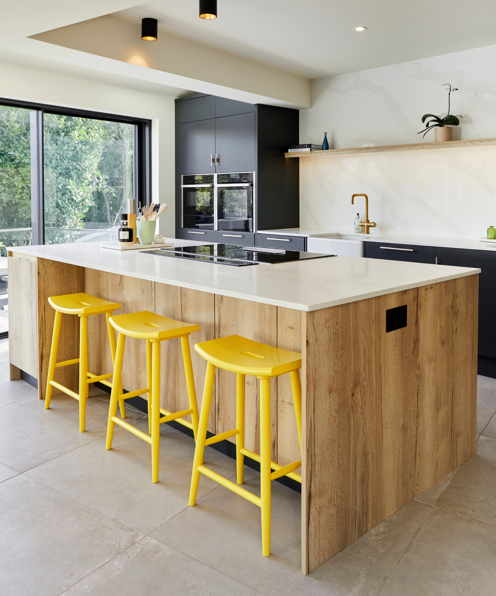 kitchen with large island, yellow bar stools, hob on island