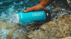 LifeSaver Liberty Water Purifier Bottle review: Pictured here, a person filling up the bottle from a stream