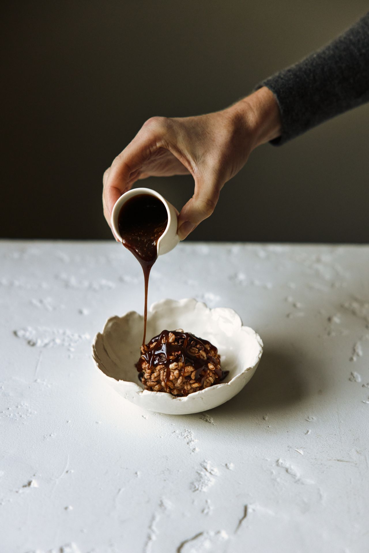 A plant-based restaurant's dishes feature greens and vegan ingredients assembled into visually striking, earthy plates served in white dishes against textural surfaces.
