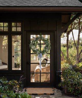 Black painted exterior with spring wreath on door