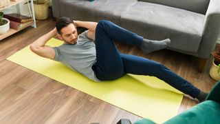 Man doing bicycle crunches at home