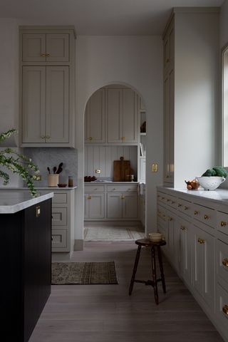 large arched door leading onto a shaker style pantry