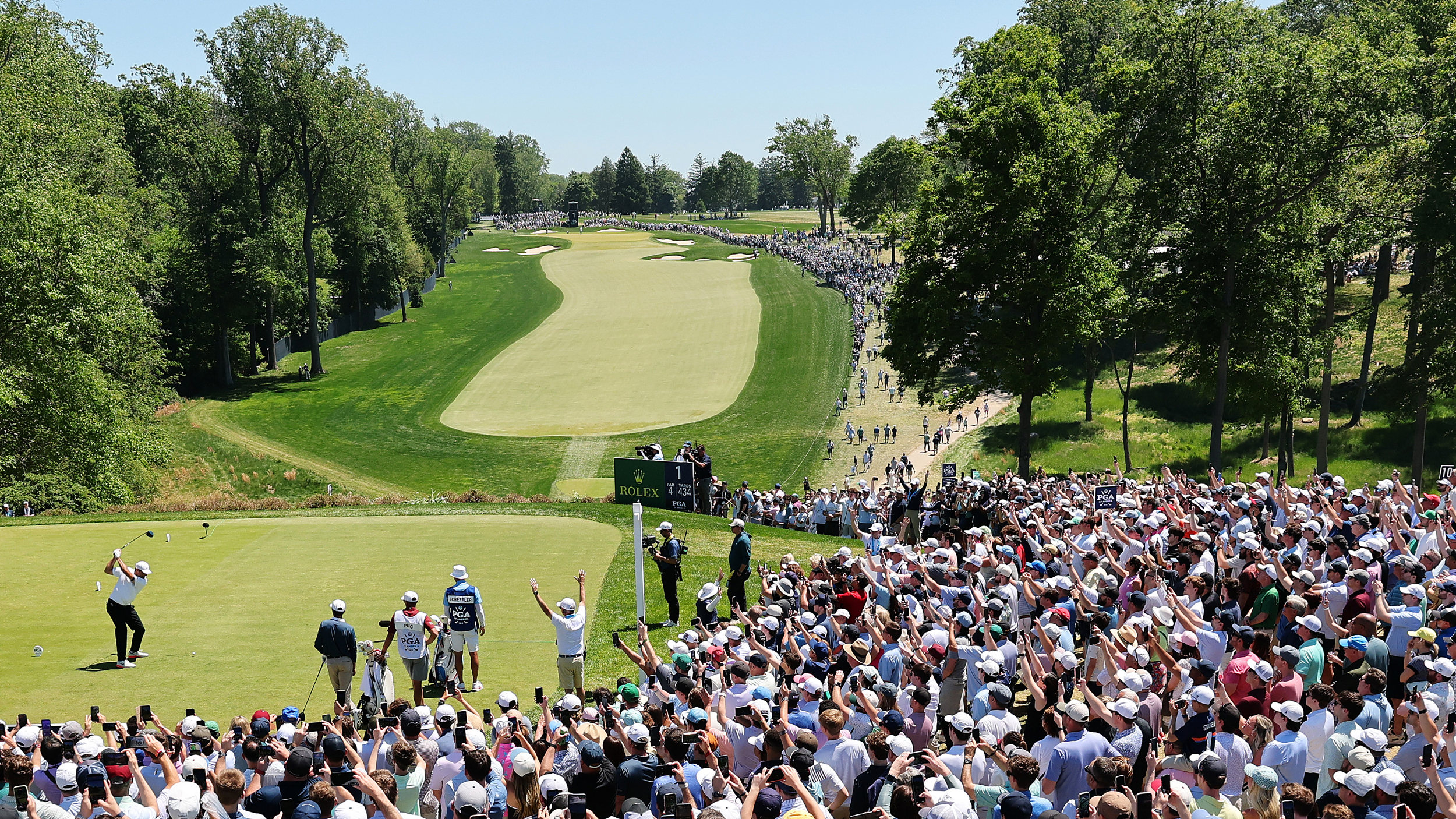 Looking down the 1st at Aronimink in the 2026 PGA Championship as Scottie Scheffler tees off in front of a huge crowd