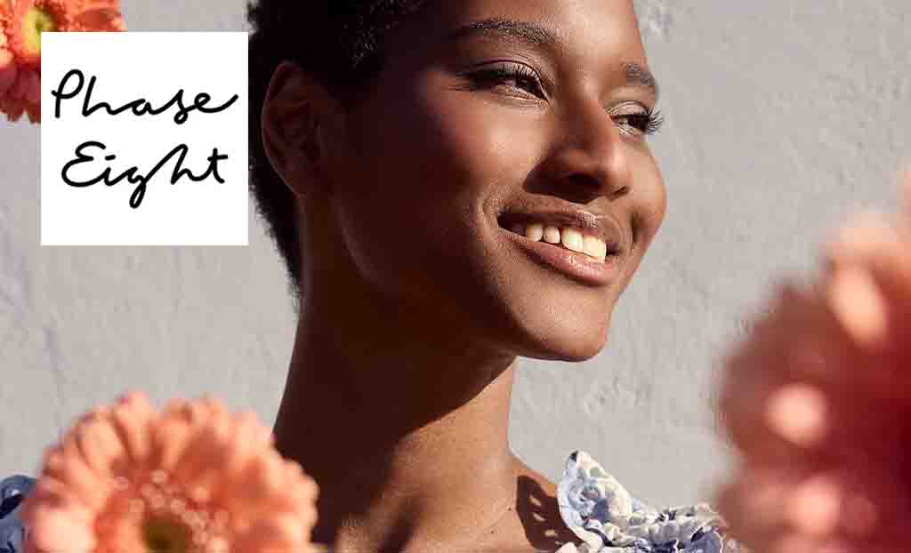 Phase Eight logo placed over a close up shot of a woman posing with peach flowers