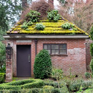 A red brick house with a green roof