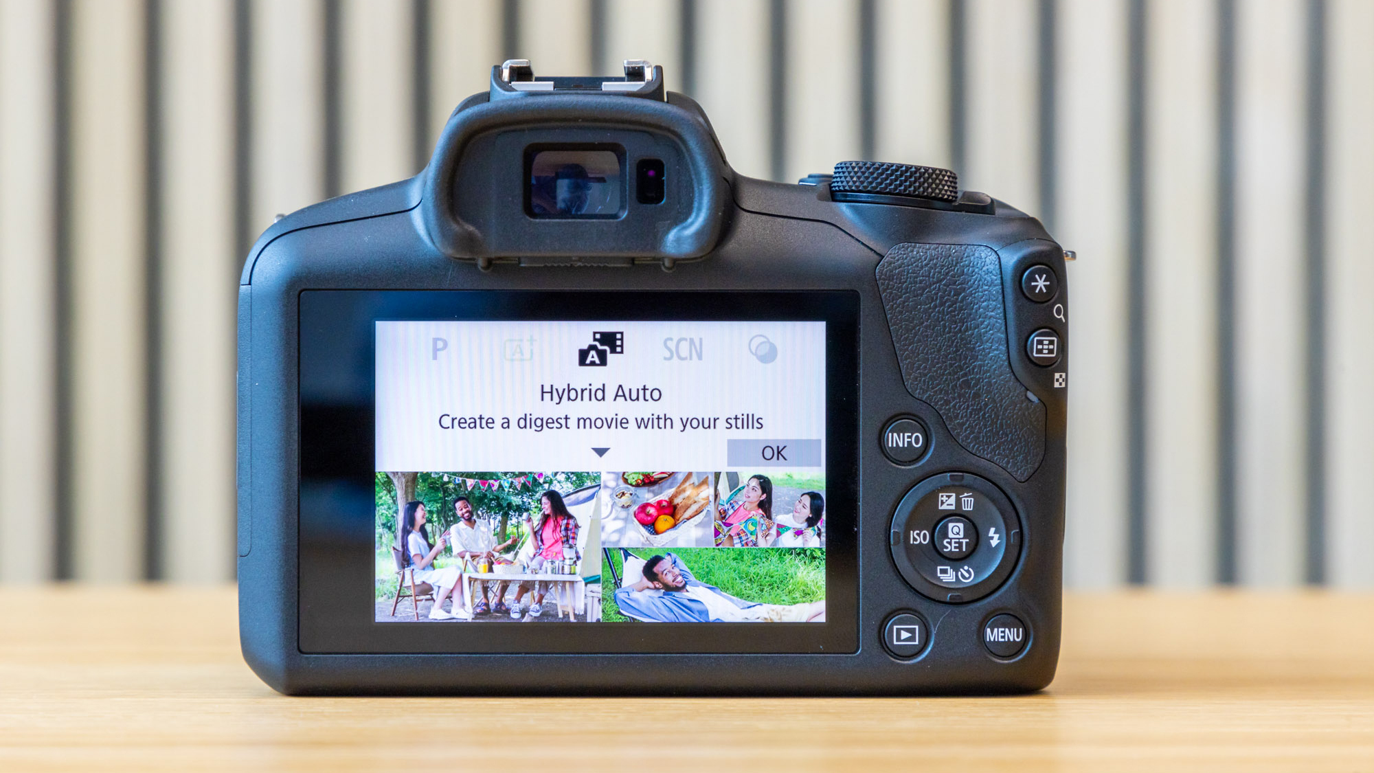 Canon EOS R100 camera on a table with a striped background