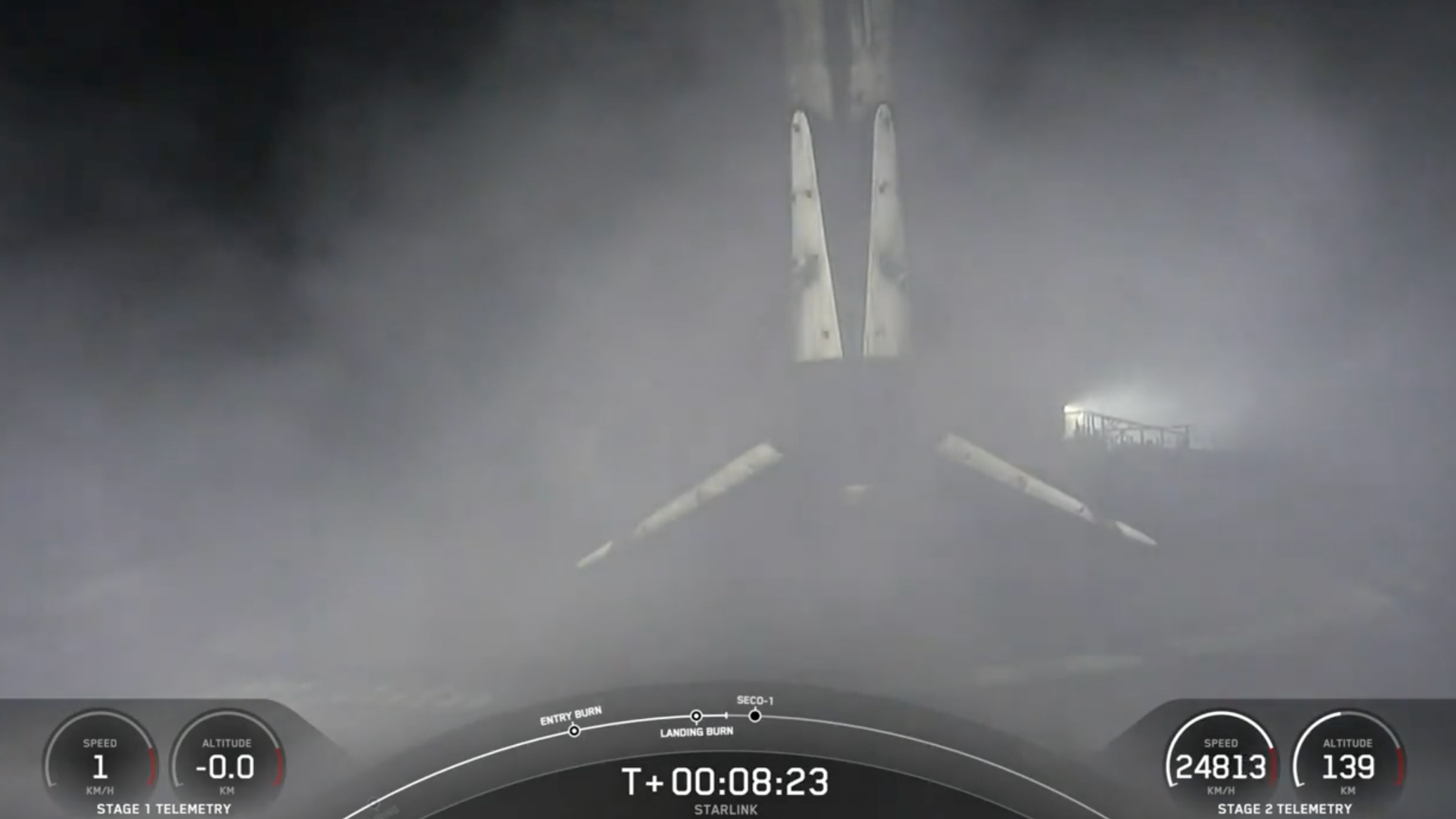 A black and white spacex falcon 9 rocket first stage sits on the deck of a ship at sea.