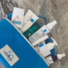 Flatlay picture of la roche posay skincare products in blue washing bag