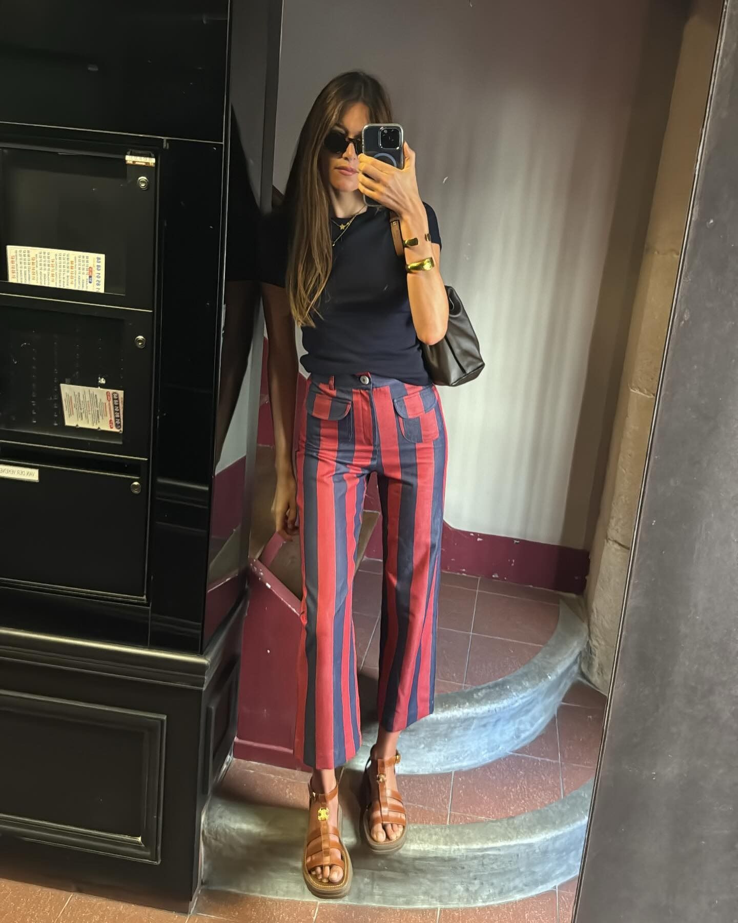 Influencer Sara wears blue and red striped pants with a black tank.