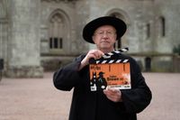 Father Brown season 12 star Mark Williams holding a clapperboard