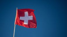 Swiss flag waving in a blue sky in St.Moritz on December 21, 2024