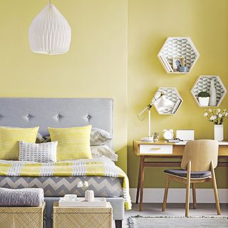 bedroom with grey sofa and lemon wall