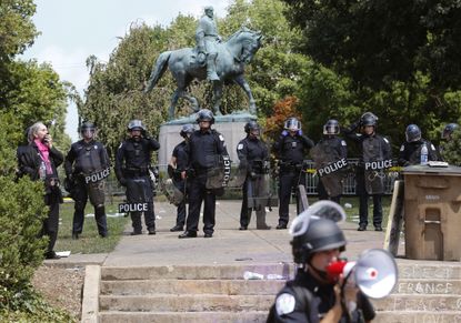 Virginia State Police in riot gear guard Lee Park after a white nationalist demonstration was declared illegal in Charlottesville.