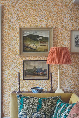 A background of orange floral wallpaper and a red and white striped lampshade