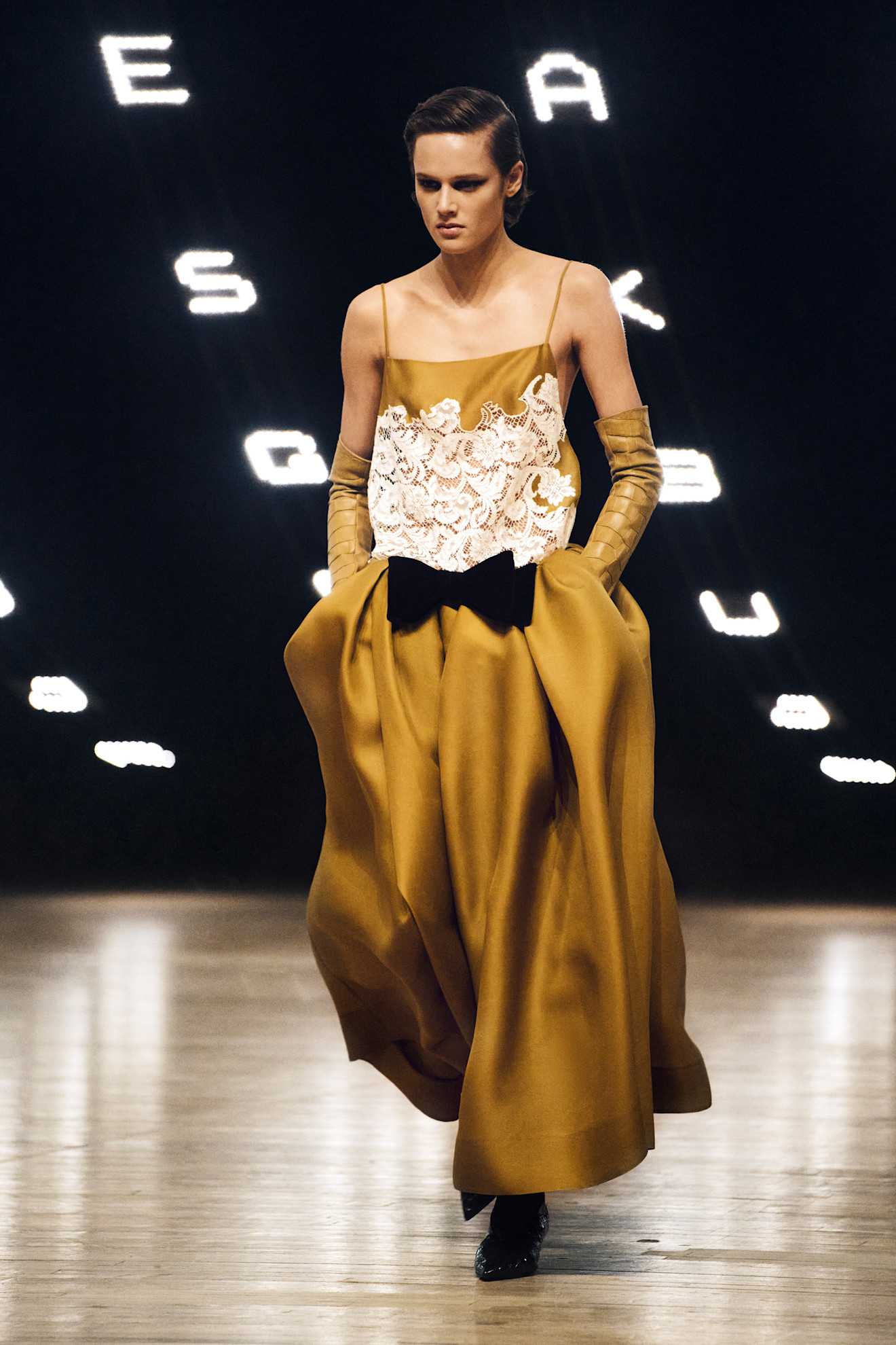 a Khaite runway look from the fall/winter 2026 collection that features the ochre color trend