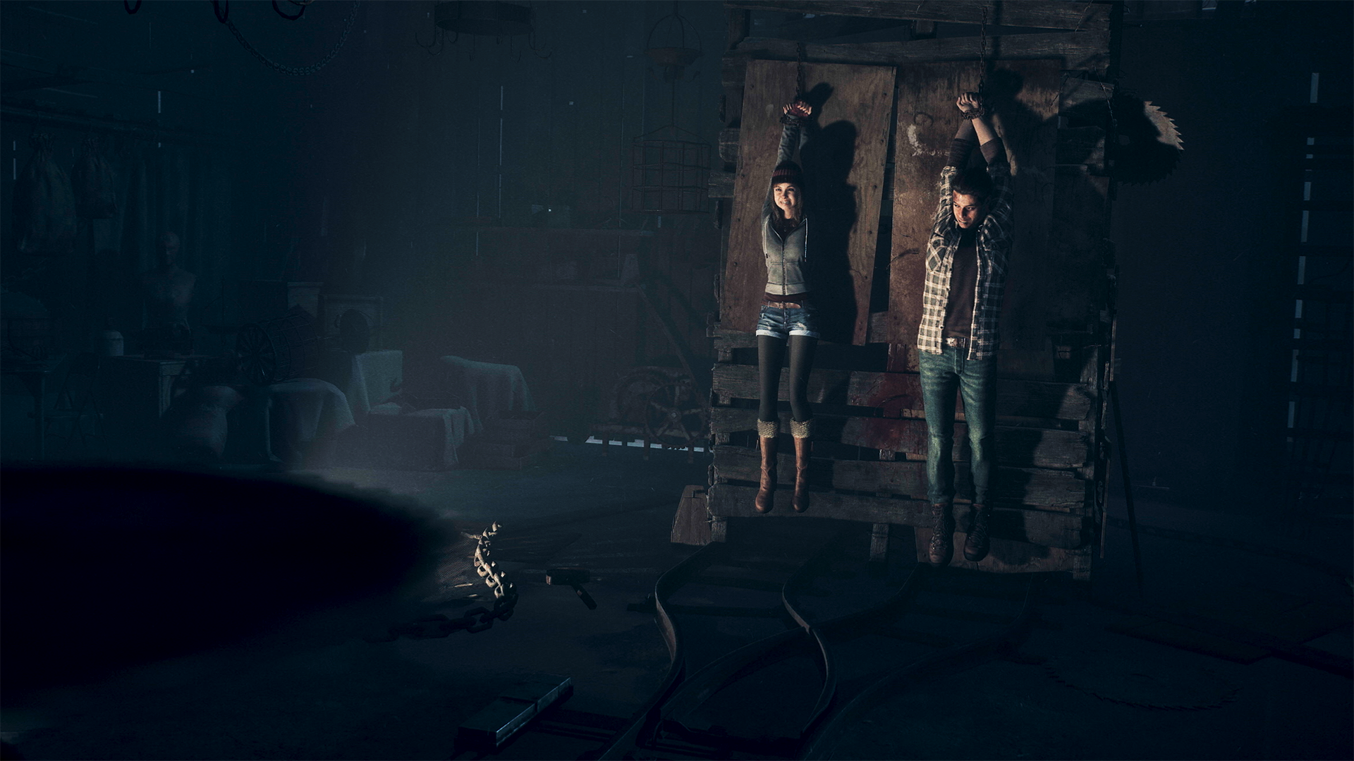 Until Dawn on PS5 – two teenagers hanging from hooks as a murderer closes in