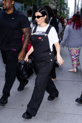 Kourtney Kardashian walks in overalls in New York City