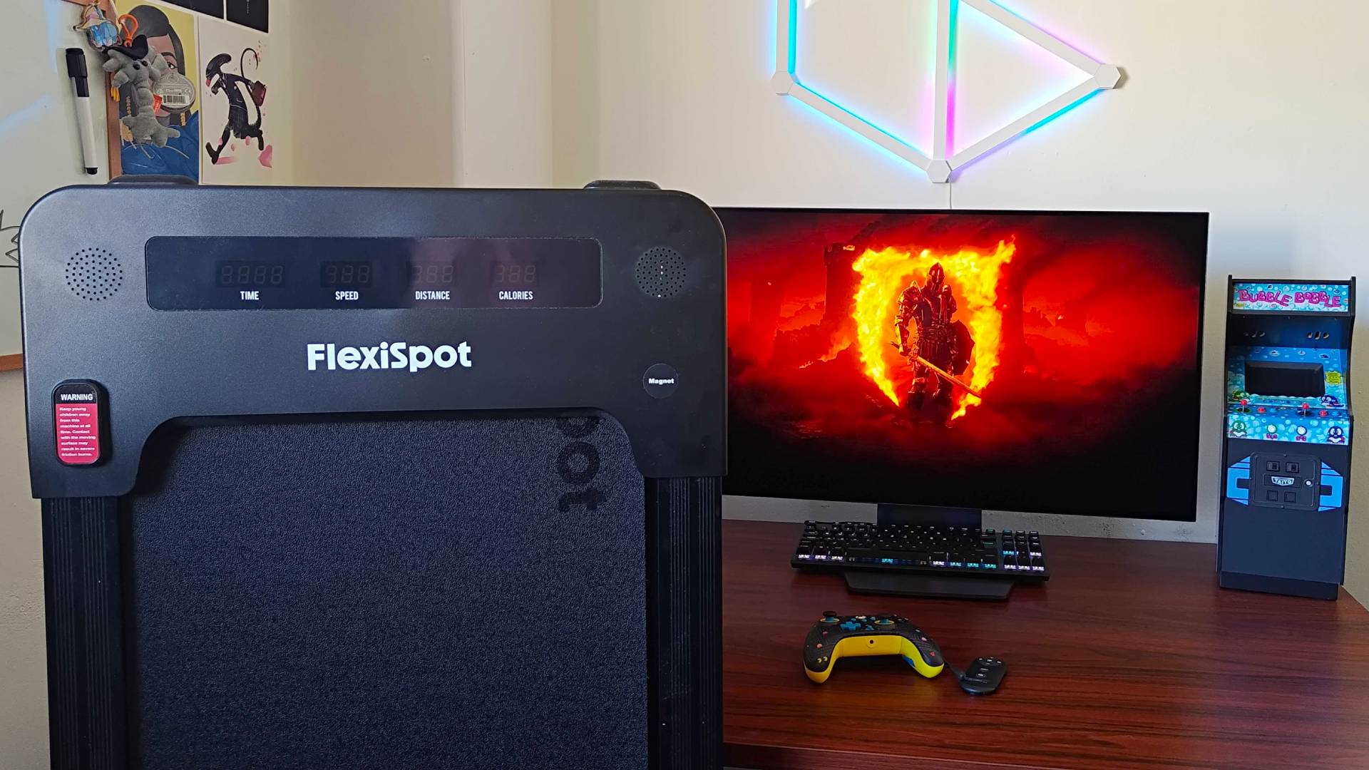 Flexispot Under Desk Treadmill upright against E7 Plus desk with Oblivion title screen on monitor in backdrop.