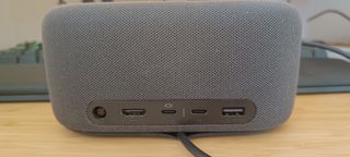 A grey Microsoft Audio Dock sitting on a wooden desk