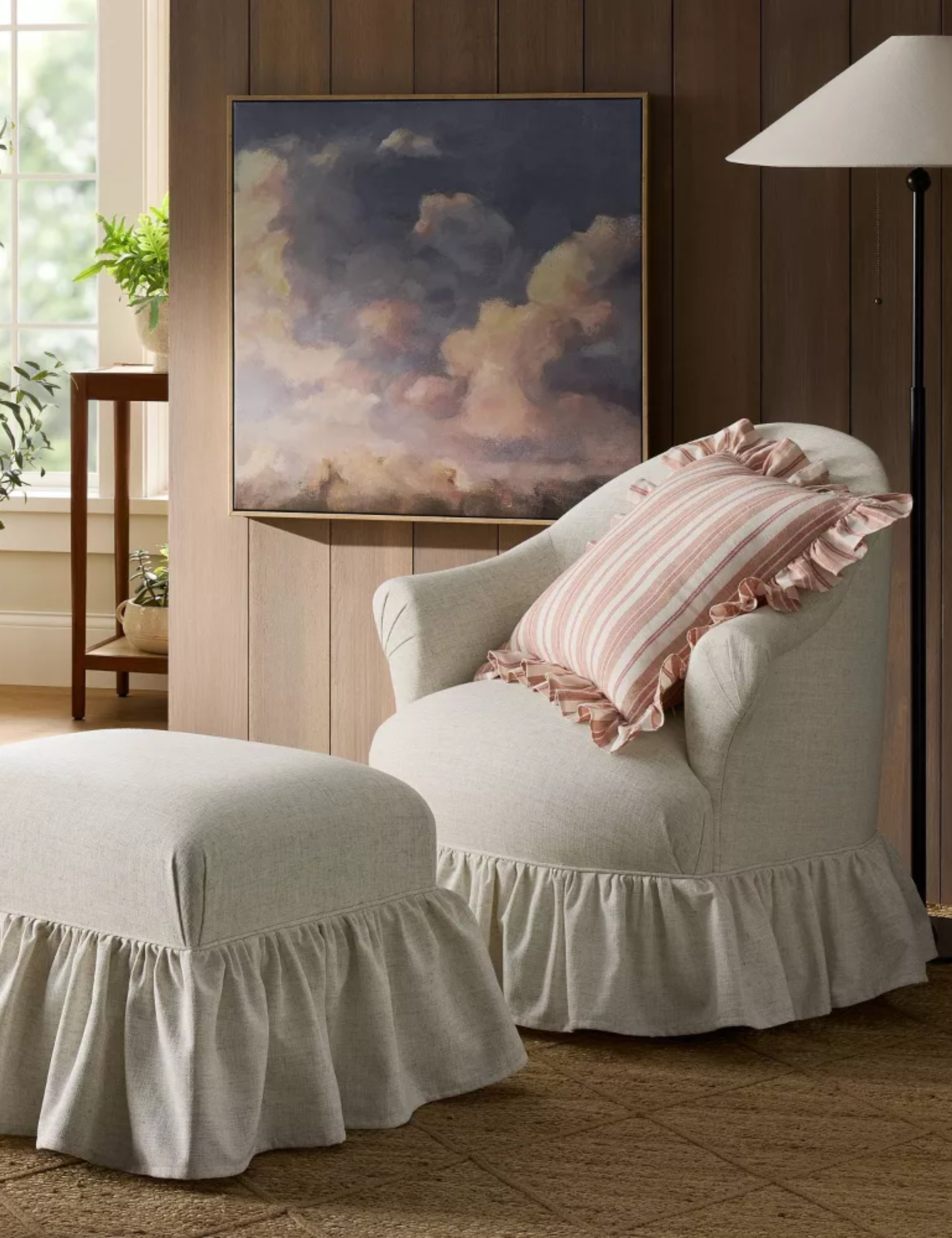 Shea McGee-designed ruffle swivel chair and matching ottoman pictured in a wood-paneled living room