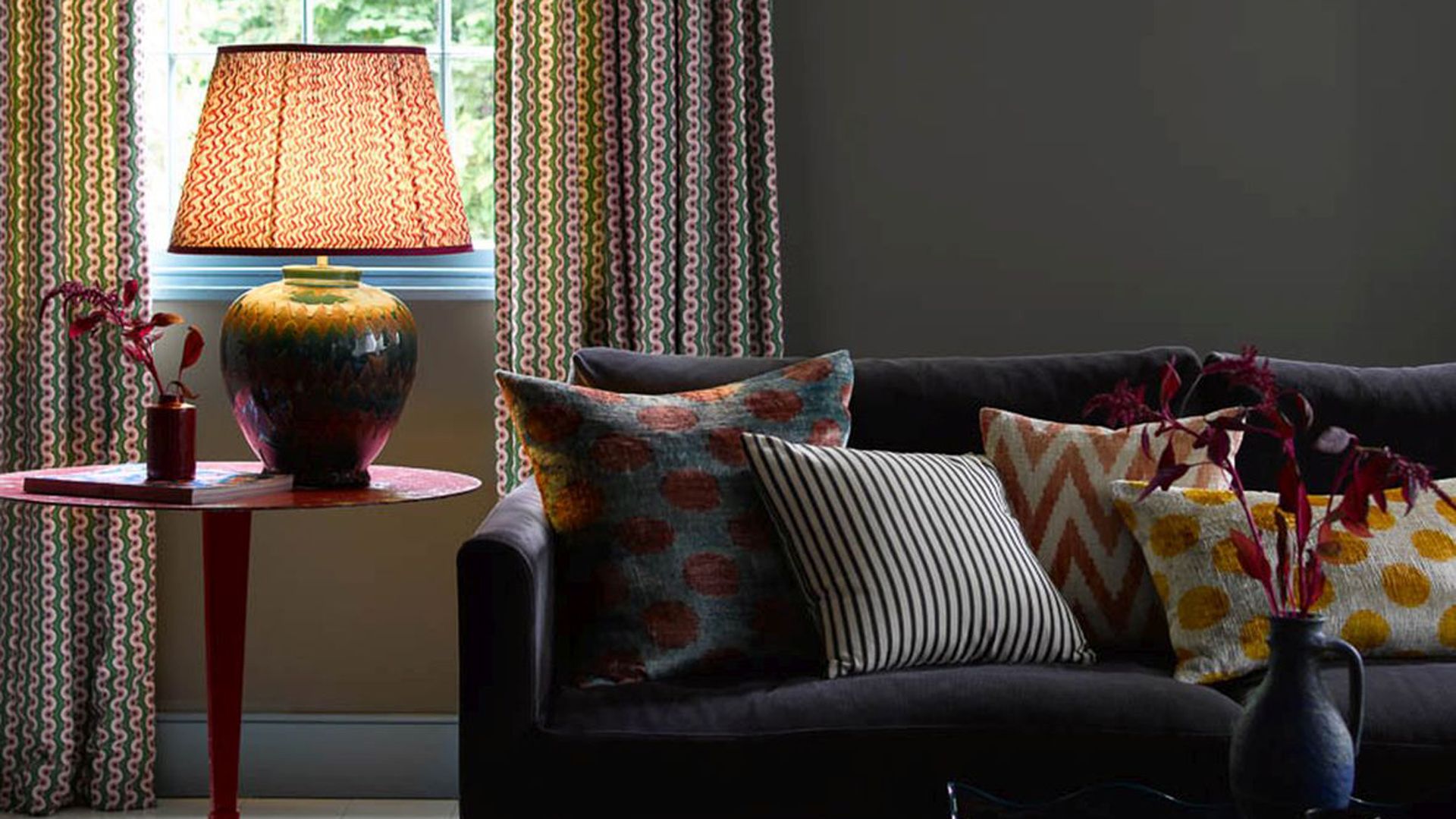 Dark painted living room with table lamp showing how to make a home cozy in winter with lighting