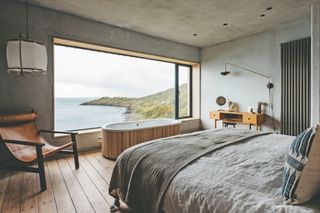 large renovated bedroom with freestanding bath and view to sea through large window