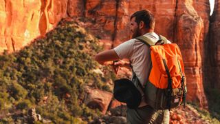 Man hiking in canyon checking smartwatch