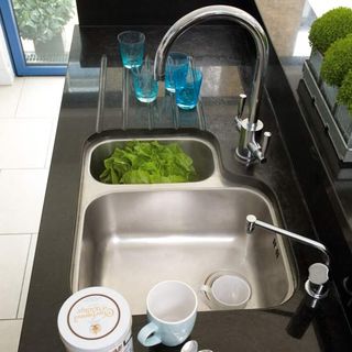 kitchen sink with tiled flooring and blue glasses