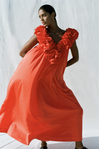 A model wearing a red floral dress by Mara Hoffman