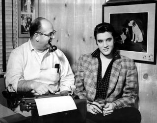A black and white photo of Elvis (right) and Colonel Tom Parker (right)