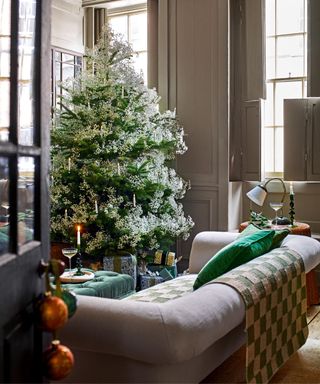 christmas traditional living room with a large christmas tree decorated with gypsophila and clip on candles