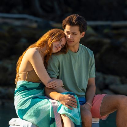 sadie soverall as percy and matt cornett as sam sitting on a dock together in every year after