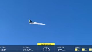 a white aircraft flies under blue skies