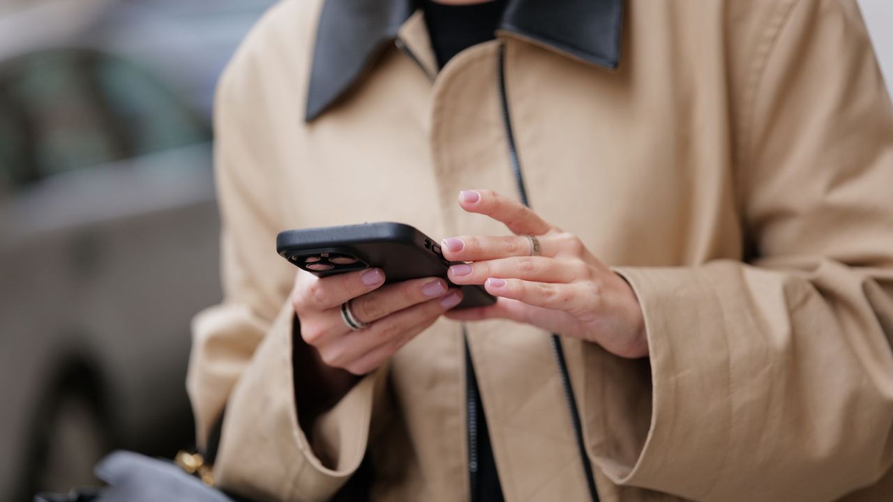 Woman with bb cream nails on her phone