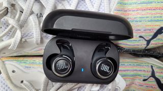 the jbl reflect flow pro earbuds in their charging case