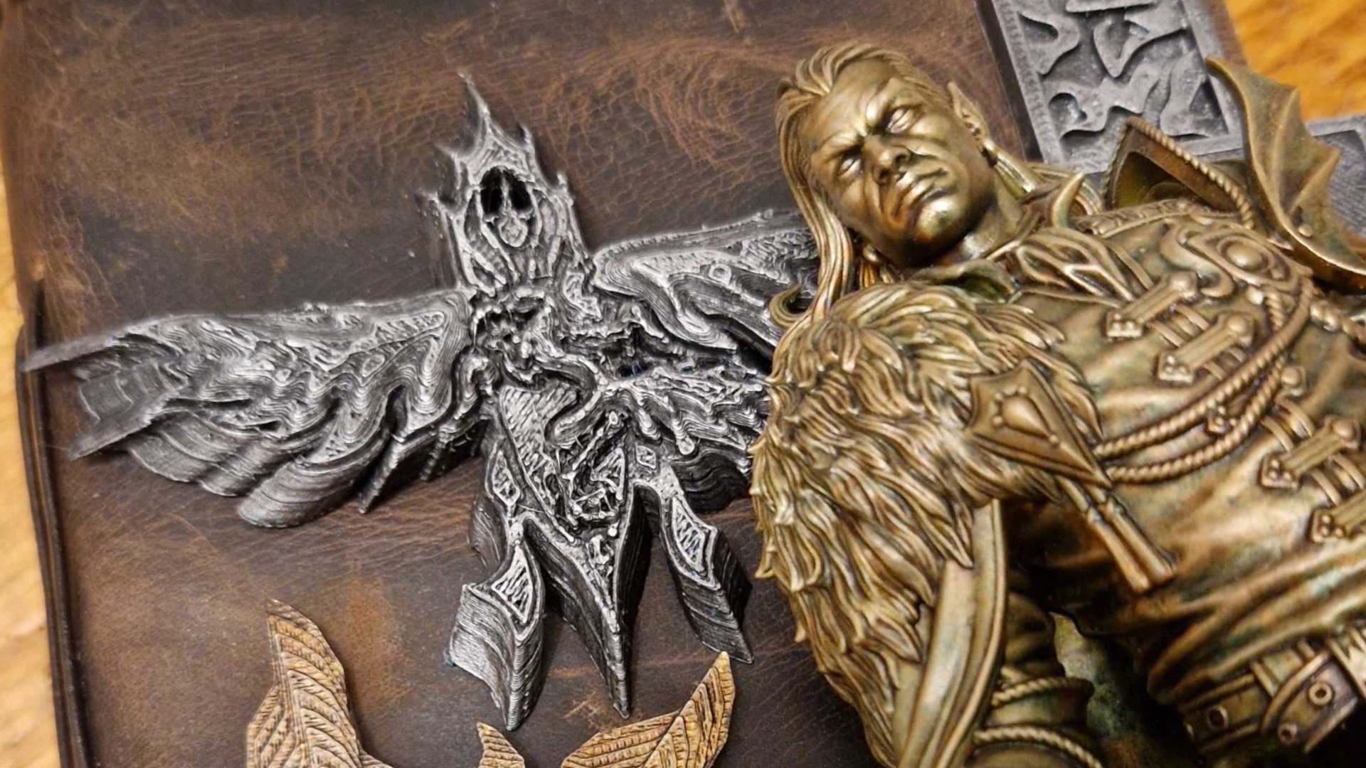 Curse of Strahd bust and crest lying on a leather notebook