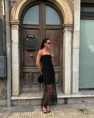 fashion influencer @sobalera wearing a Gia studios black sheer dress and black Toteme sandals