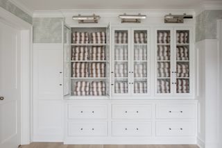 cupboard with glass doors and folded towels