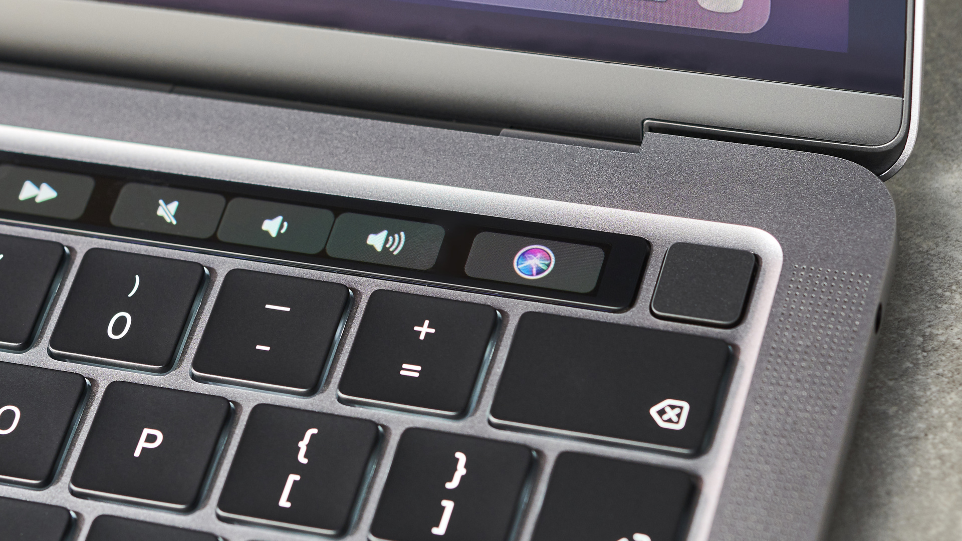 Apple MacBook Pro 13-inch (M1, 2020) on a desk showcasing its keyboard and power button/fingerprint reader