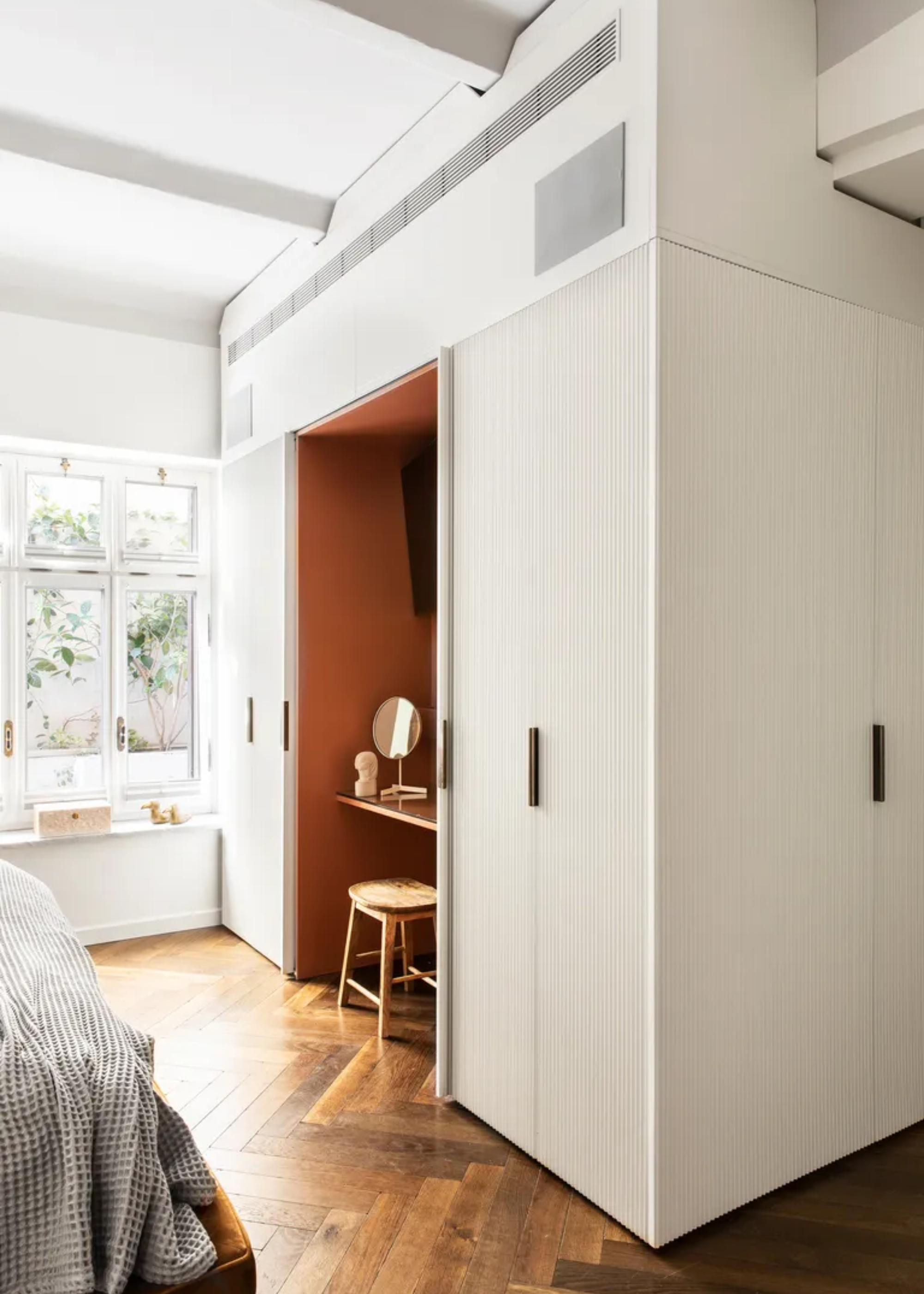 A bedroom with a vanity and white closet cupboards