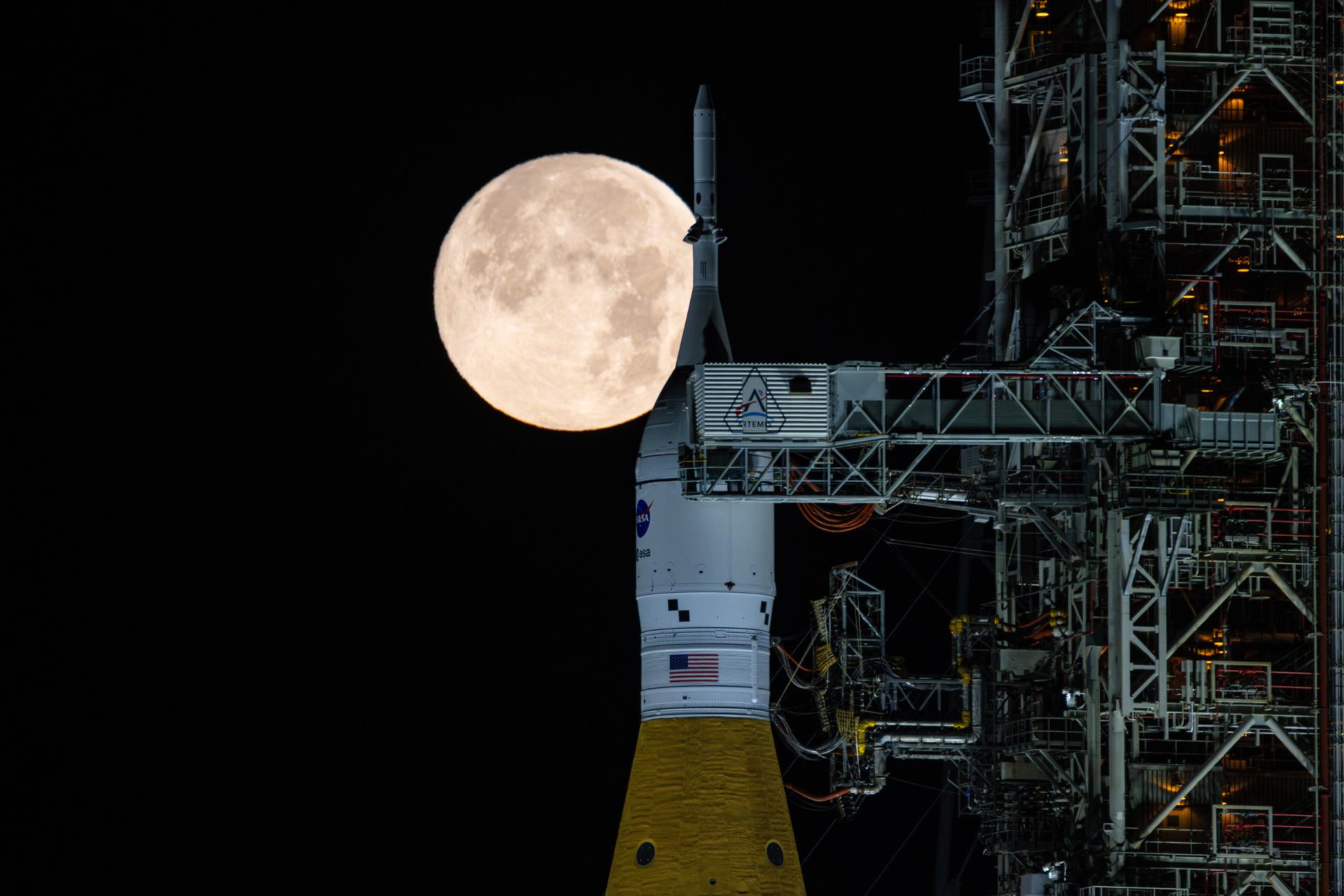 The full moon rises over the Artemis II rocket stack in February, 2026
