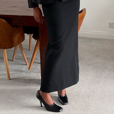 Woman in black skirt and black high-vamp pumps