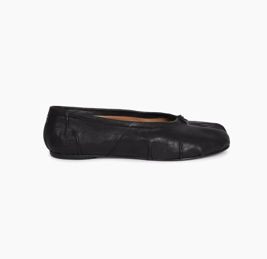 a pair of maison margiela tabi flats in front of a plain backdrop