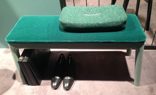 Green soft bench with shoes underneath