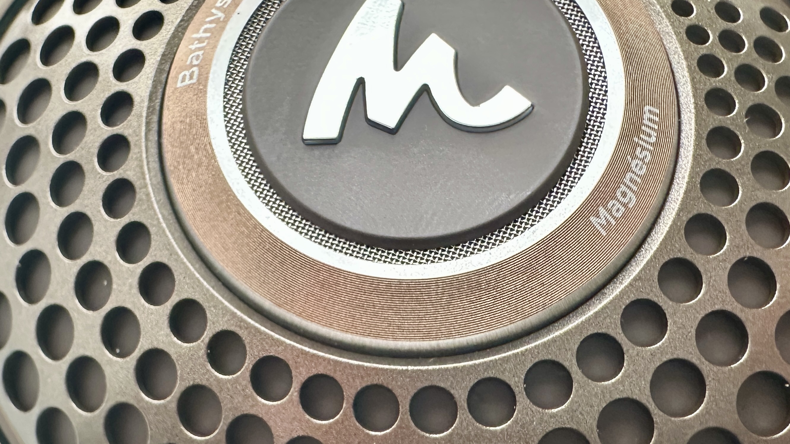 Focal Bathys Mg in bronze, featuring ear cup detail on gray background